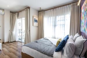 een slaapkamer met een bed en een groot raam bij 4BR Luxury Pool Villa Siri Craft House Nimman in Chiang Mai +46 foto's