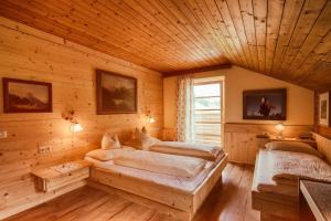 a bedroom with two beds in a log cabin at Almi's Berghotel in Obernberg am Brenner