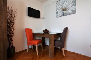 a dining room table with two chairs and a tv on a wall at Apartment Garden M&M in Dubrovnik