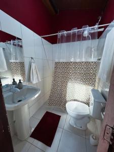 a bathroom with a white toilet and a sink at Casa na Estrada Real - Tiradentes in Tiradentes