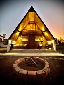 a large wooden house with a fire pit in front of it at La Encantada Cabañas in Cajamarca