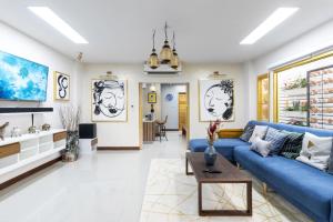 een woonkamer met een blauwe bank en een tafel bij 4BR Luxury Pool Villa Siri Craft House Nimman in Chiang Mai