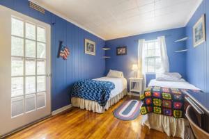 a blue room with two beds and a window at Cozy Homeva Kensico WP in White Plains