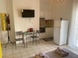 a kitchen with a refrigerator and a table and chairs at Stelios apartment 1 in Chios +4 photos
