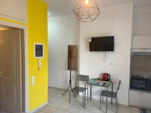 a living room with a table and a yellow wall at Stelios apartment 1 in Chios