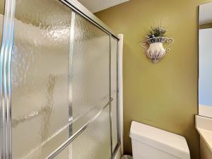 a bathroom with a shower and a toilet with a vase on the wall at Deep Creek Village #31 in McHenry +27 photos