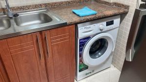 a kitchen with a sink and a washing machine at Private room for ladies near metro in Dubai