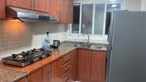 a kitchen with a stove and a stainless steel refrigerator at Private room for ladies near metro in Dubai