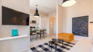 a living room with a tv and a table with chairs at Carmo 43 in Lisbon