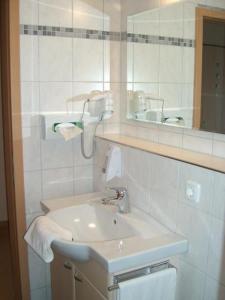 uma casa de banho branca com um lavatório e um espelho em Zur Morschbach em Altlay