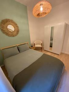 a bedroom with a large bed and two mirrors at THE COSY HOME Centre ville Parking Clim in Valence
