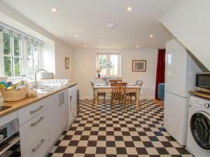 a kitchen with a table and a checkered floor at Rose Cottage in Hereford