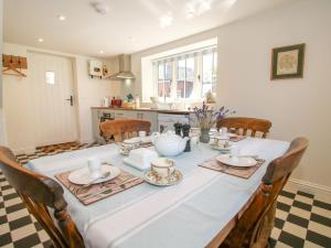 a dining room table with a blue table cloth and chairs at Rose Cottage in Hereford