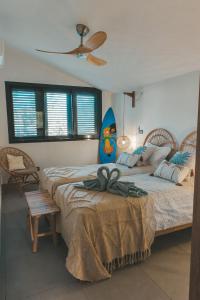 a bedroom with two beds and a surfboard at Villa Denise 4 étoiles - 8 Voyageurs in Petite Île +31 photos