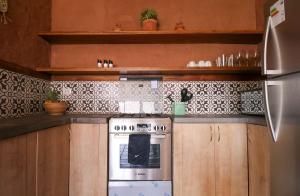 Una cocina con estufa y gabinetes de madera. en Amazing 2BR House in Valle Sagrado, en Urubamba