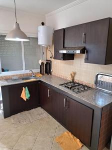 a kitchen with a sink and a stove top oven at Chalet Villa de Luxe - Piscine in Dchar Aït Belkassem