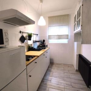 cocina con armarios blancos y suelo de baldosa en Apartments Miss Katy, en Zagreb