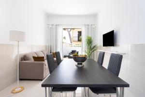 a living room with a dining room table with chairs at Two apartments 250m from las americas Beach in Playa de las Americas +54 photos
