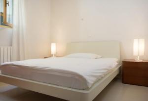 ブレラにあるBrela Center Modern Apartmentのベッドルーム(白いベッド1台、ランプ2つ付)