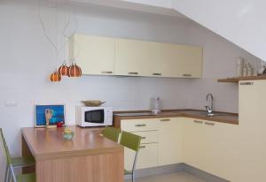 ブレラにあるBrela Center Modern Apartmentのキッチン(白いキャビネット、電子レンジ付きテーブル付)