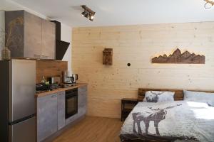 a kitchen with a bed and a refrigerator in a room at Wohnung Heuberg im Inntal mit Hot Tube - zentral & ruhig in Flintsbach am Inn