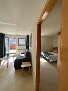 a living room with a bed and a couch in a room at AT home Avenida del Ejercito in Guadalajara