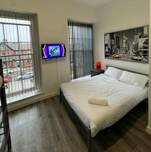 a bedroom with a bed and a tv on a wall at Westgate Apartments in Newcastle upon Tyne