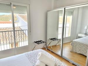 a white bedroom with two beds and a balcony at Apartment with terrace in Ardales