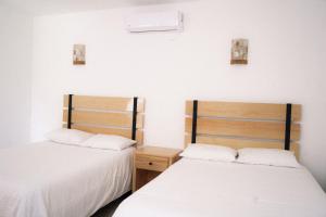 two beds sitting next to each other in a room at Hotel EL Porvenir in Tunas Blancas +63 photos