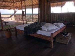 a bed in a room with a view of the ocean at Lar Torus Eco Lodge - Kite is Surf in Tatajuba