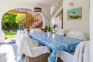 a dining room with a table and white chairs at Villa Letizia Santa Luria Sea View - IUN R9232 in Quartu SantʼElena
