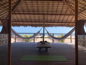a room with a hammock and a table in a pavilion at Lar Torus Eco Lodge - Kite is Surf in Tatajuba +101 photos