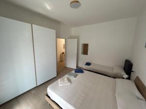 a white bedroom with two beds and a tv at Borromini apt Como-Cernobbio in Como +14 photos