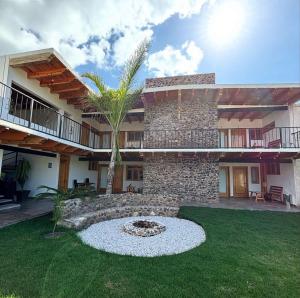 a house with a palm tree in the yard at Hotel EL Porvenir in Tunas Blancas