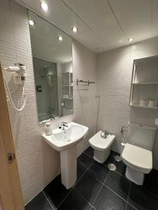 a bathroom with a sink and a toilet and a mirror at AT home Santo Domingo in Guadalajara +28 photos