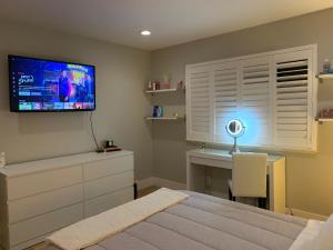 Un dormitorio con una cama y un televisor en la pared. en White Cloud Room, en San José
