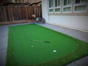 un putting green con palos de golf y bolas en él en White Cloud Room, en San José
