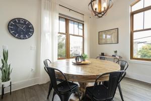 a dining room with a wooden table and a clock on the wall at Franklin On Main in Blowing Rock