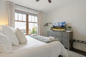 a bedroom with a bed with white pillows and a window at Franklin On Main in Blowing Rock +13 photos