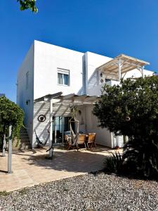 a white house with two chairs and a porch at Sea House Lahania in Lachania