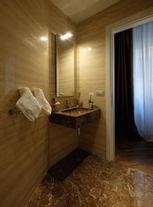 La salle de bains est pourvue d'un lavabo et d'un miroir. dans l'établissement Navona Rooms, à Rome