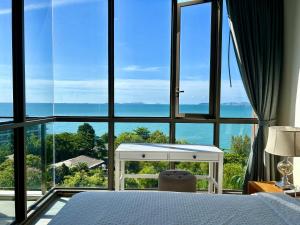 a bedroom with a bed and a large window at Cosy seaview two bedrooms Nakula in North Pattaya