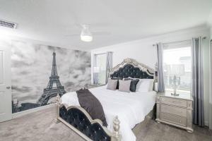 a bedroom with a bed with a mural of the eiffel tower at EPIC STYLISh retreat With Free water park near Disney in Kissimmee +81 photos