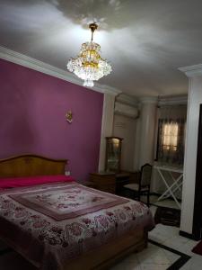ein Schlafzimmer mit einem großen Bett und einem Kronleuchter in der Unterkunft فيللا في التجمع الأول in Kairo