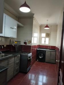 eine Küche mit Waschmaschine in der Unterkunft فيللا في التجمع الأول in Kairo