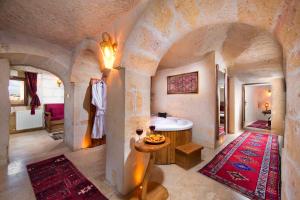 a bathroom with a tub and a sink in a room at Portal Cappadocia - Adults Only Cave Hotel in Ortahisar