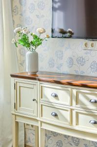a vase with flowers on top of a dresser at Elegant apartment in Old town Vilnius SELF CHECK IN 24x7 by H&H in Vilnius +16 photos