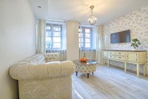 a living room with a couch and a tv at Elegant apartment in Old town Vilnius SELF CHECK IN 24x7 by H&H in Vilnius