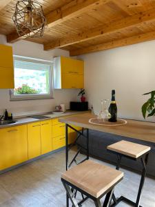 cocina con armarios amarillos, mesa y ventana en Villa Paradise, en Banja Luka