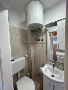 Un baño pequeño con inodoro y lavabo. en Villa Paradise, en Banja Luka 19 fotos más